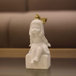 Escultura em Resina Branca Menina com Laço Dourado